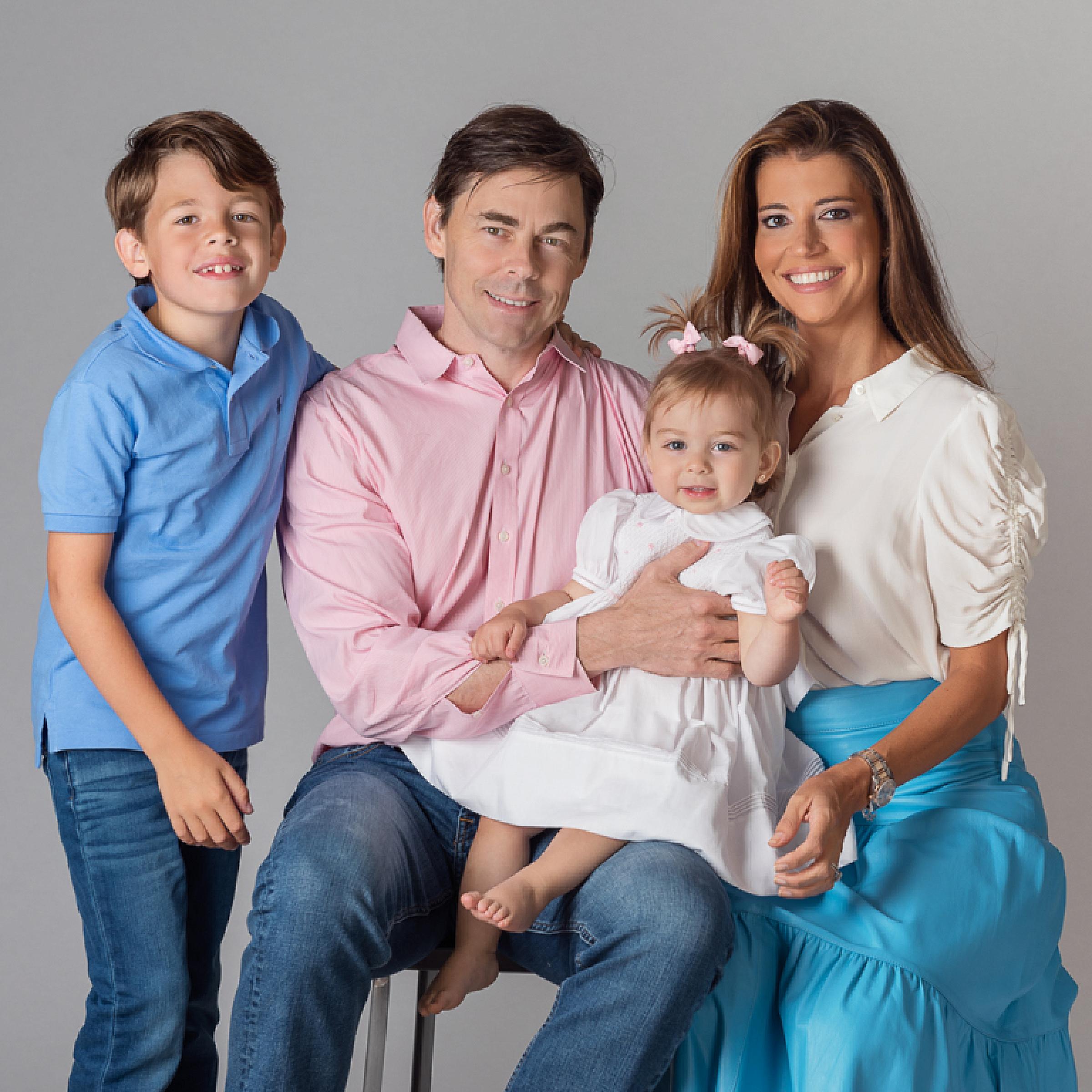 Fernanda and Chase Sheridan with their young son and daughter sitting for a family portrait.